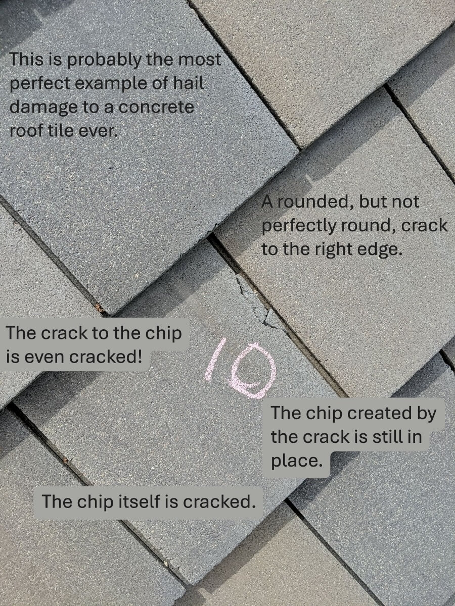 A rounded crack on a concrete tile where the chip is still present and also cracked.
